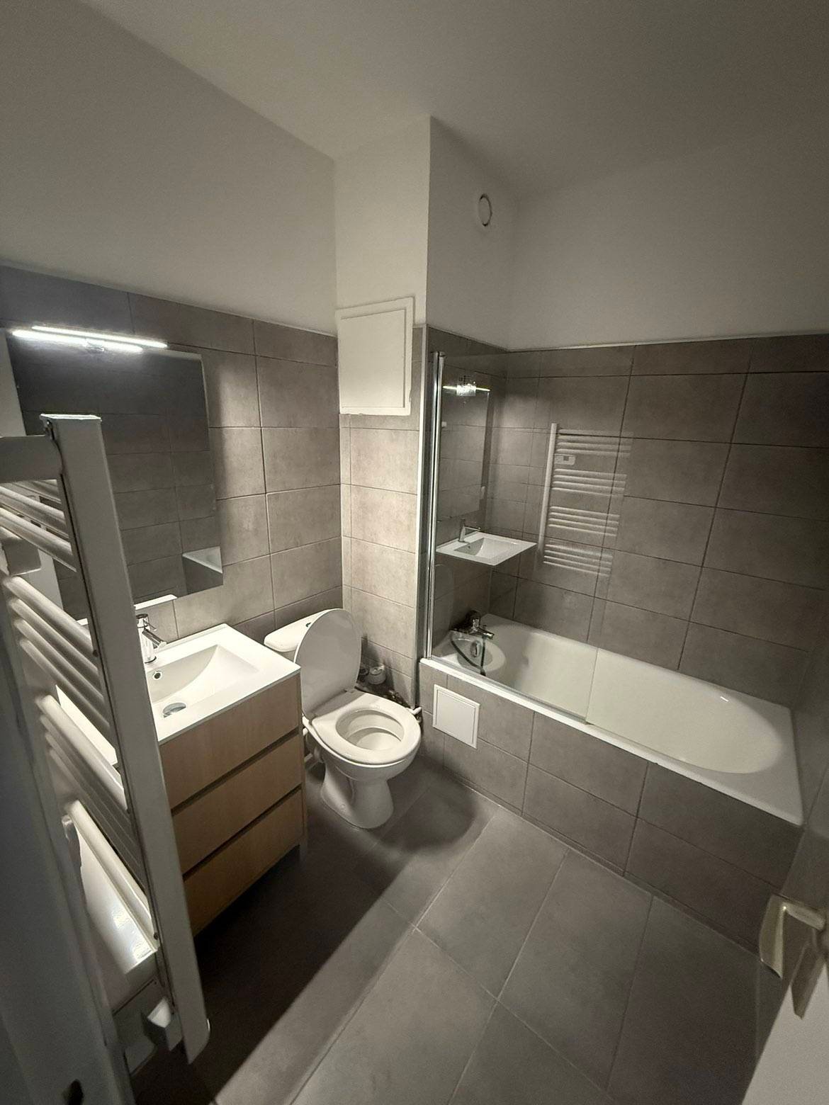 Salle de bain rénovée, meuble vasque, baignoire et sèche-serviettes