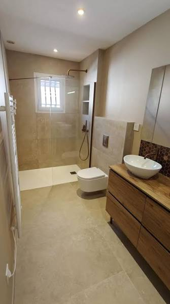 Salle de bain terminée avec douche à l’italienne et vasque posée