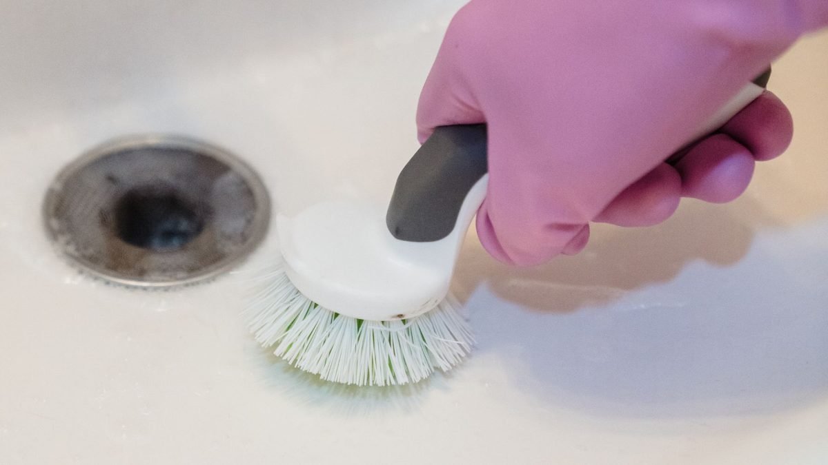 Nettoyage de la bonde d’un évier à la brosse